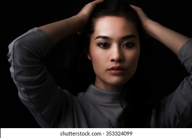 Young Asian Woman With Long Hair On Dark Background.