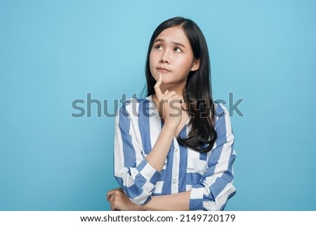 young asian woman look up considering think and doubt why
