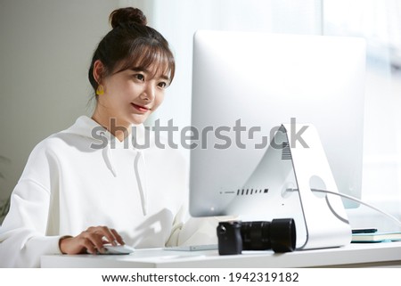A young Asian woman looking at the monitor