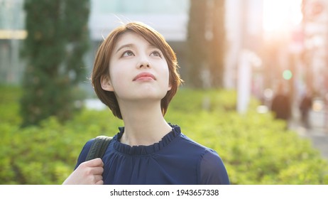 Young Asian Woman Looking Up To Sky.