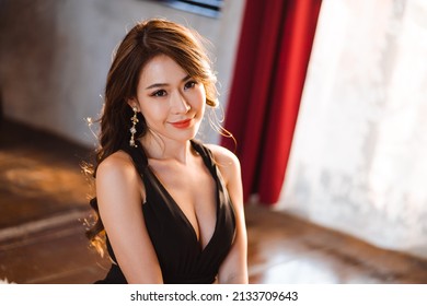 Young Asian Woman In Luxury Black Dress Is Looking At Camera