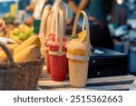 Young Asian woman makes smoothies and colorful fresh fruits at a health-conscious juice bar. which promotes health and nutrition, watermelon smoothie and orange smoothie, mango in a wicker basket.