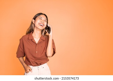 Young Asian Woman Making A Call Using A Cell Phone On Isolated Background