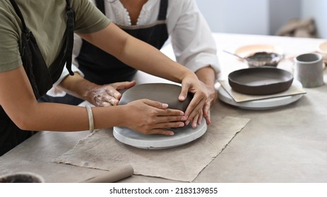 Young asian woman and mature woman molding clay, enjoy making handcrafted ceramics in pottery workshop - Powered by Shutterstock