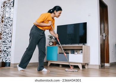 Young Asian woman moping floor in the living room - Shutterstock ID 2366434301