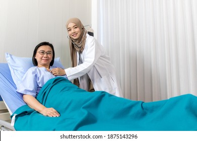 Young Asian Woman Muslim Doctor Check Up To Elderly Patient At Hospital. Medicine And Health Care Safe Concept
