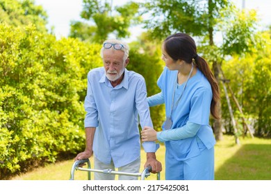 Young Asian Woman Nurse Care Giver Helping Senior Old Man With Mobility Walker In Garden At Home. Senior Daycare Center, Nurse Take Care Elderly Patient With Cheerful Concentrate