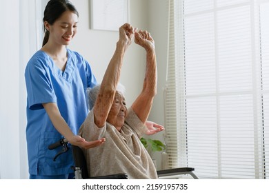 Young Asian Woman Nurse, Caregiver Assist A Senior Asian Woman To Do Physical Therapy And Exercise Arms At Home