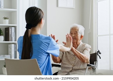 Young Asian Woman Nurse, Caregiver Assist A Senior Asian Woman To Do Physical Therapy And Exercise Arms At Home