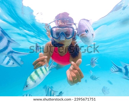 Young Asian woman on a snorkeling trip at Samaesan Thailand. dive underwater with fishes in the coral reef sea pool. Travel lifestyle, watersport adventure, swim activity on a summer beach holiday 