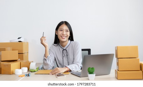 Young Asian Woman Is An Online Merchandiser And Is Currently Managing Conversations And Receiving Orders From Customers Via The Internet, Selling Products Online Or Doing Freelance Work At Home.