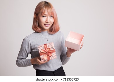 Young Asian Woman Open A Golden Gift Box On Gray Background