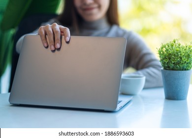 A Young Asian Woman Opening A Laptop Computer, Getting Ready For Work In Office