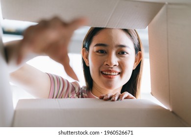 Young Asian Woman Opens The New Package That Has Been Sent Home
