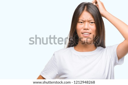 Young asian woman over isolated background confuse and wonder about question. Uncertain with doubt, thinking with hand on head. Pensive concept.