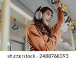 Young Asian Woman Passenger and Listening Music, Using Mobile Smartphone in Subway Sky Train. Lifestyle in City and Daily Urban Life. Transportation Concept