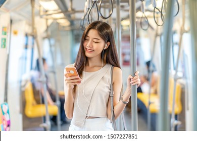 Young Asian woman passenger listening music via smart mobile phone in subway train when traveling in big city,japanese,chinese,Korean lifestyle and daily life, commuter and transportation concept - Shutterstock ID 1507227851