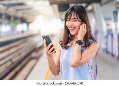 Young Asian woman passenger listening music via smart mobile phone in subway train when traveling in big city,japanese,chinese,Korean lifestyle and daily life, commuter and transportation concept - Shutterstock ID 1906467598