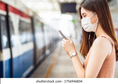 Young Asian woman passenger wearing surgical mask and listening music via smart mobile phone in subway train when traveling in big city at Covid19 outbreak, Infection and Pandemic concept - Shutterstock ID 1756946834