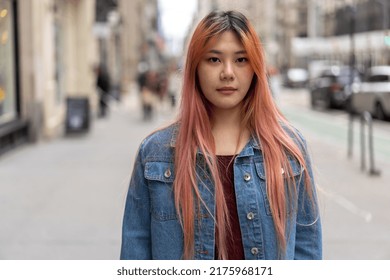 Young Asian Woman With Pink Dyed Hair On A City Street Serious Face Portrait