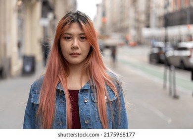 Young Asian Woman With Pink Dyed Hair On A City Street Serious Face Portrait