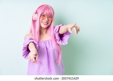 Young Asian Woman With Pink Hair Posing On Green Background