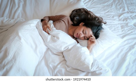 Young Asian Woman In Plain T-shirts On The Luxury White Bed.