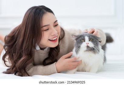 Young Asian Woman Playing With Cat At Home