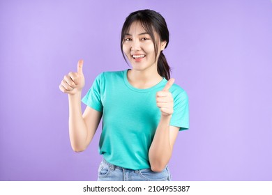 Young Asian woman posing on purple background