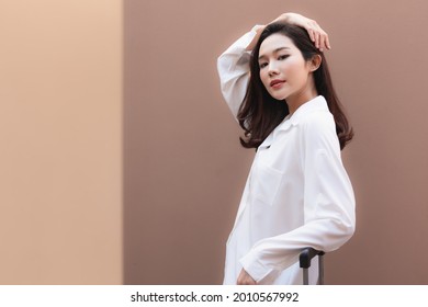 Young Asian Woman Posing In Trendy Look. Portrait Of A Smiling Brunette Women Natural Makeup Wear Fashion Clothes. Beautiful Female Model Wearing A Big White Shirt. People Beauty Concept.