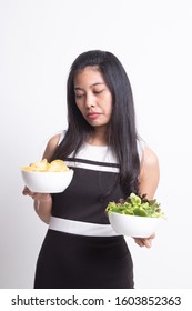 Young Asian woman with potato chips and salad on white background