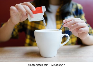 Young Asian Woman Pouring Sugar Into Mug.