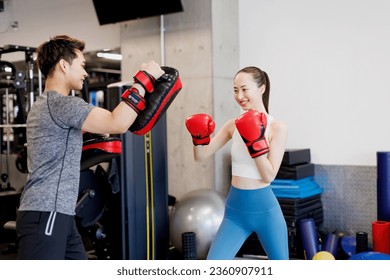 Young Asian woman practice boxing with personal trainer - Powered by Shutterstock