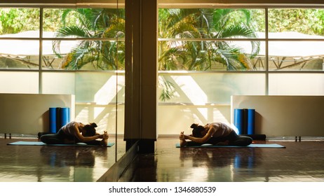 Young Asian Woman Prepare For Yoga Training By Streching Back And Legs With Very Flexible Body Reflection In Window