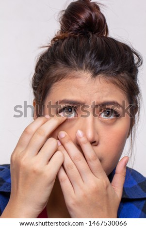 Young asian woman putting clean and clear contact lens into eyes, eyewear care concept. isolated on white background.