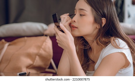 Young Asian Woman Putting Mascara Makeup In Mirror Banner Getting Ready For Work Doing Morning Makeup Routine Putting Mascara In Bathroom Mirror At Home.