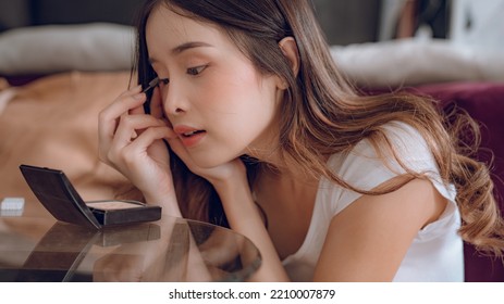 Young Asian Woman Putting Mascara Makeup In Mirror Banner Getting Ready For Work Doing Morning Makeup Routine Putting Mascara In Bathroom Mirror At Home.