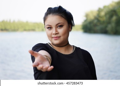 young asian woman reaching out to lend a helping hand - Powered by Shutterstock