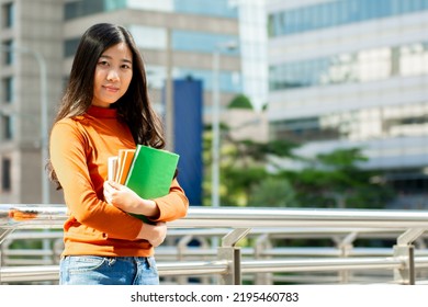 Young Asian Woman Reading Book In The University.