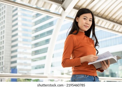 Young Asian Woman Reading Book In The University.