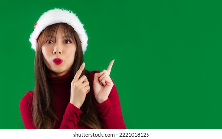 Young Asian Woman In Red Sweatshirt Wearing Santa Hat Finger Pointing Green Screen Background.