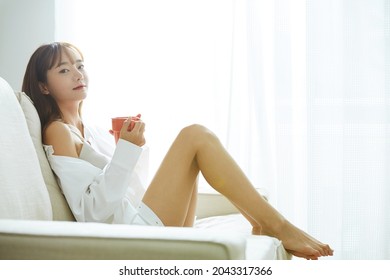 Young Asian Woman Relaxing On The Sofa