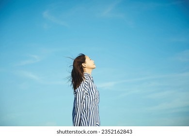 Young Asian woman relaxing outdoors - Powered by Shutterstock