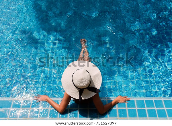 Young asian woman relaxing in swimming pool at\
spa resort.relaxing\
concept.