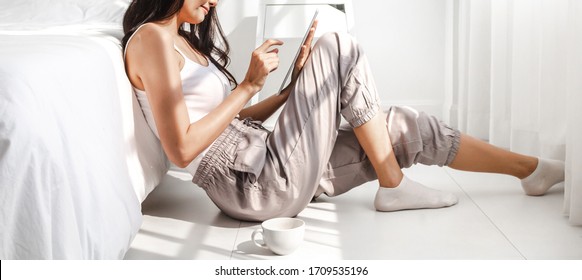Young asian woman relaxing and using digital tablet computer with on the bed at home.girl working checking social apps and play game.Communication and technology concept
