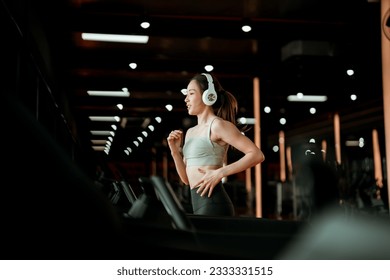 Young Asian Woman Running on Treadmill - Fitness Gym Exercise - Powered by Shutterstock