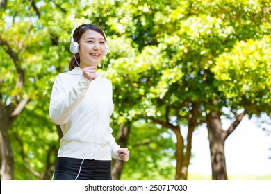 Young Asian Woman Running In The Park