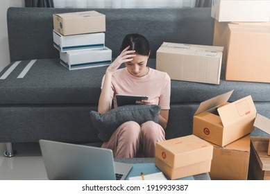 Young Asian Woman Selling Products Online Is Stressed Out Looking At A Tablet After Customers Claim Products At Home.