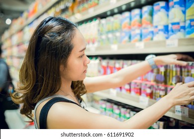 Young Asian Woman Shopping Canned Fruit In Produce Department Of A Grocery Store Supermarket