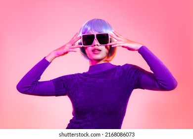 Young Asian Woman Short Blue Milinium Hairstyle Wearing Pink Sunglasses Posing On The Red Pastel And Neon Color Background.